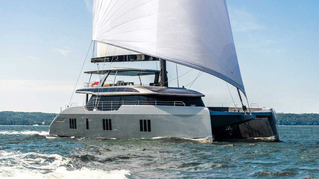 A Sunreef 80 Eco Apollo 99 sailing on the water with sails unfurled.